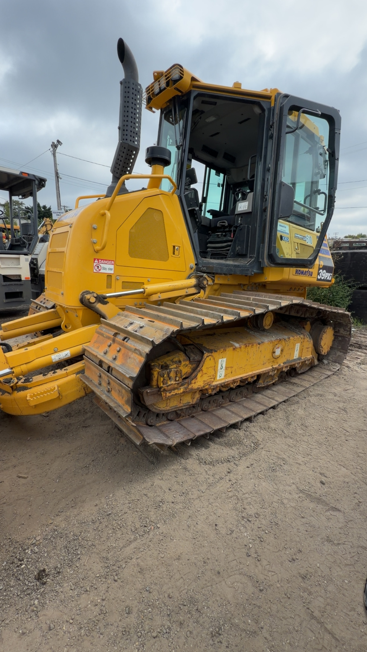 Yellow tracked dozer at an equipment yard